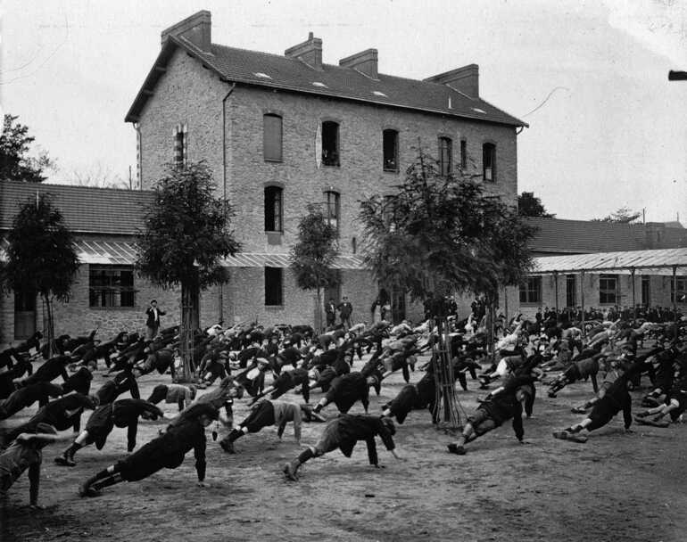 Cours de gymnastique dans la cour de l'école des garçons, boulevard de la Fraternité