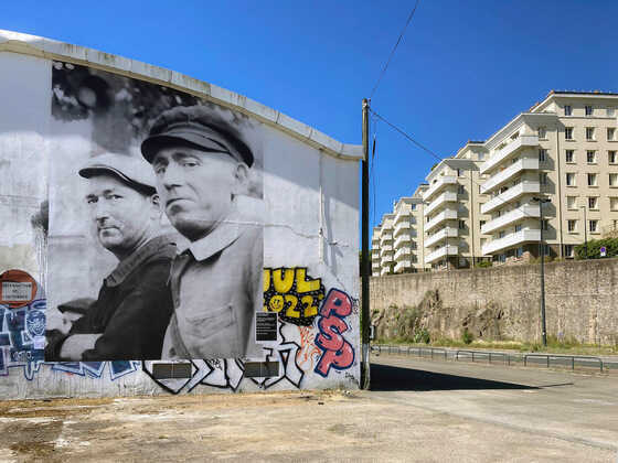Photographie collée sur le pignon du Hangar 12 sur le quai Marquis d'Aiguillon dans le cadre des événements La rue de la grue noire